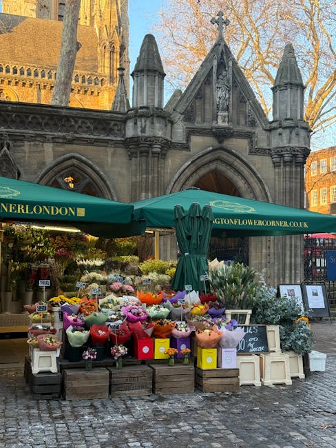 Outside the historic stone church in Kensington, a vibrant flower stand under a green canopy displays a variety of fresh floral bouquets in pastel, bright, and deep colours, wrapped in paper and silk 
